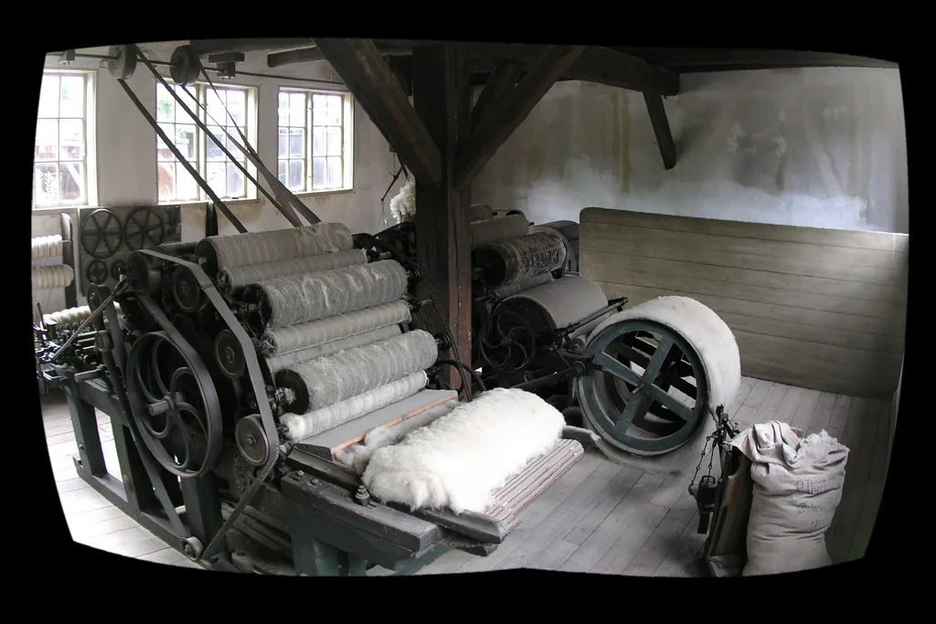 An old wool carding machine with its drums and rollers exposed