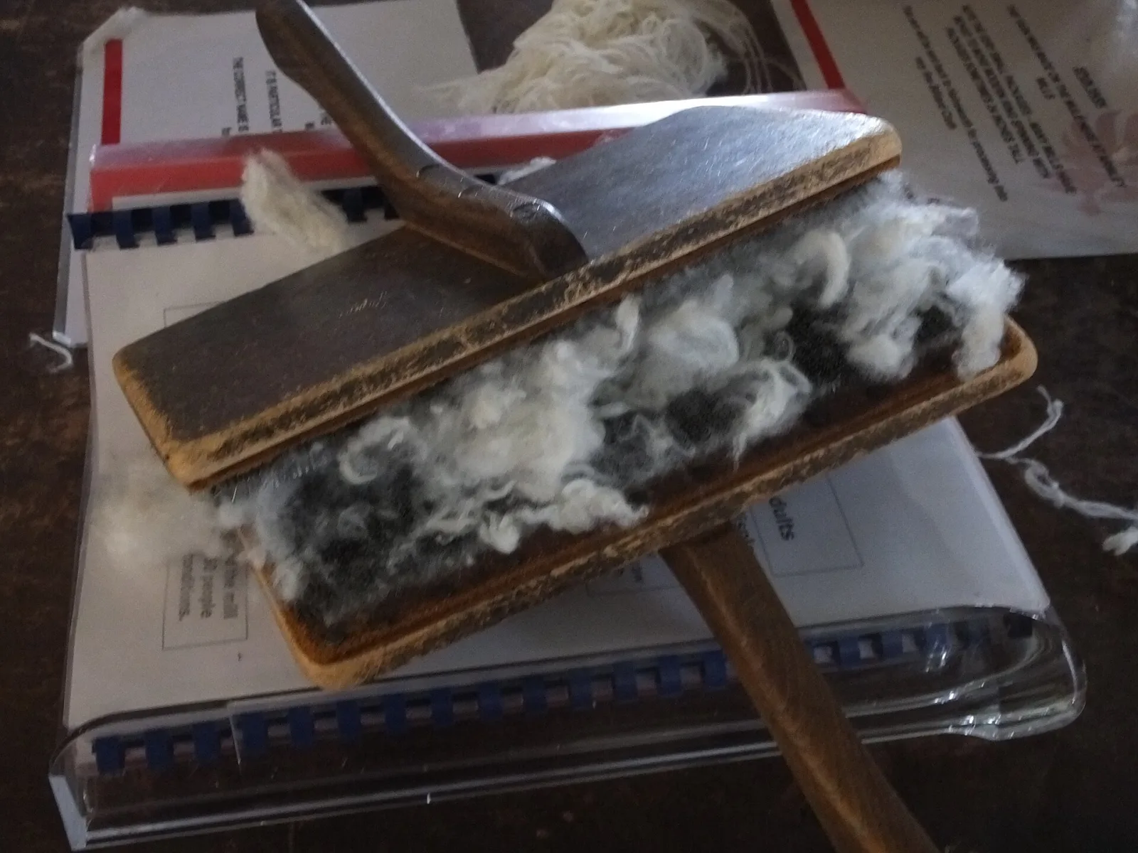 A pair of hand carders with wire teeth, used to card wool by hand