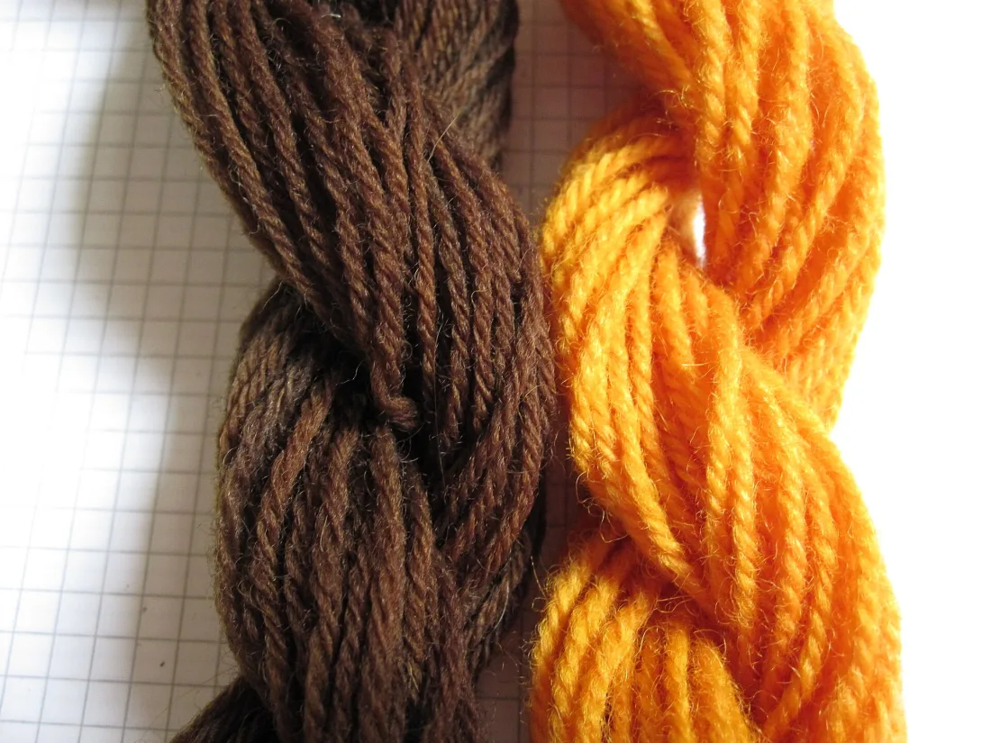 Two skeins of wool dyed brown and orange