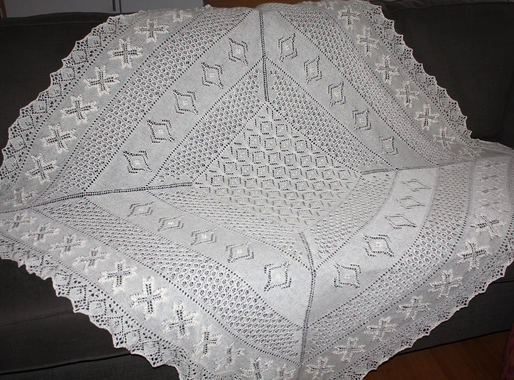 A blocked lace shawl showing the pattern in full