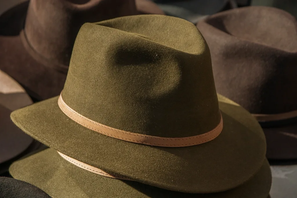 An olive green felt hat with a leather band