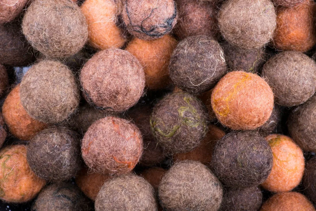 A heap of felt balls in undyed browns, grays and soft orange