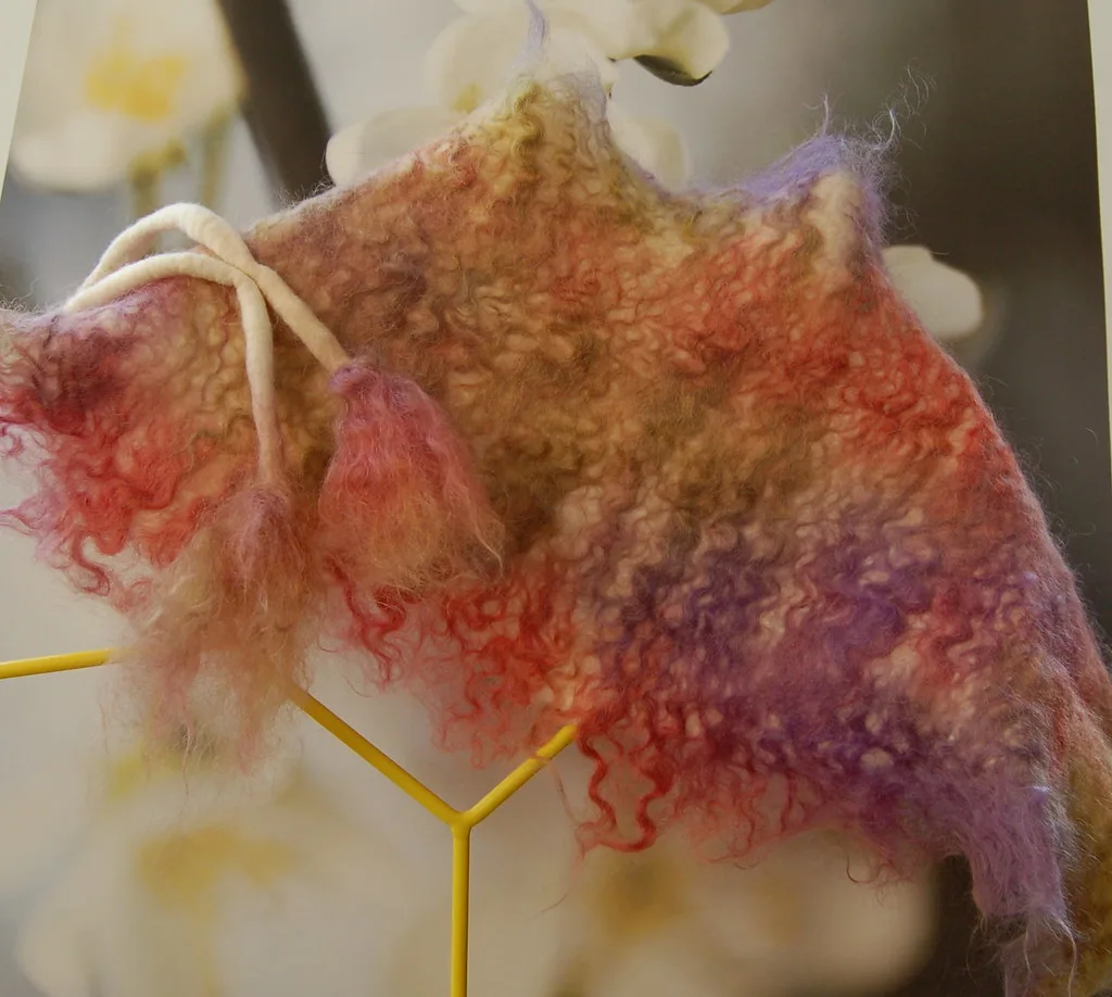 Wet-felted merino and mohair scarf in red, gold and purple, with curly mohair locks standing out from the felt surface