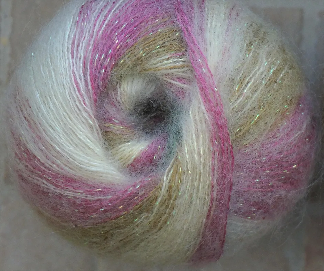Ball of fluffy brushed mohair yarn in pink, white and gold with a fine sparkle thread
