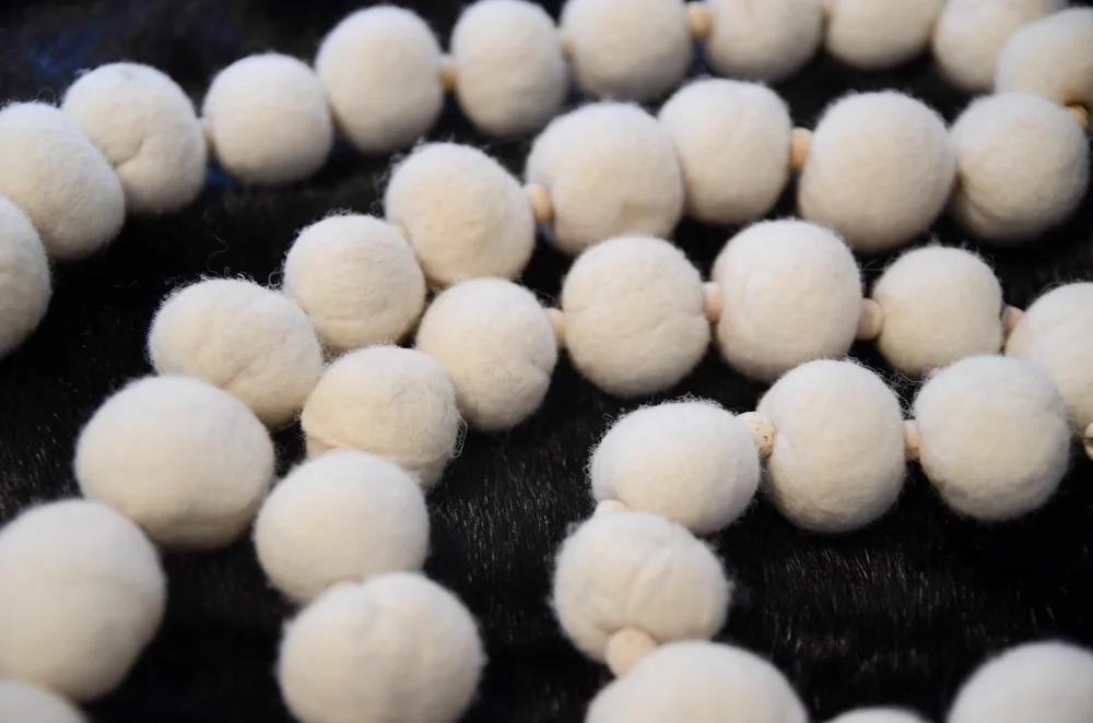 Firm felted wool balls strung together
