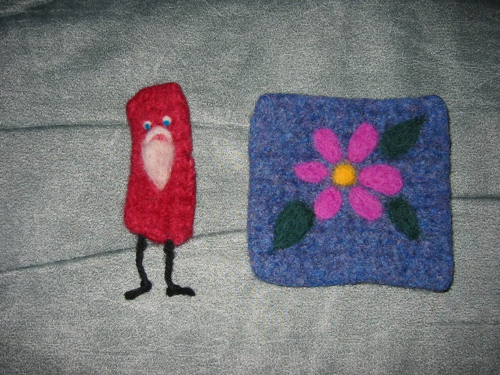 Needle felted work: a small figure and a flat felted panel