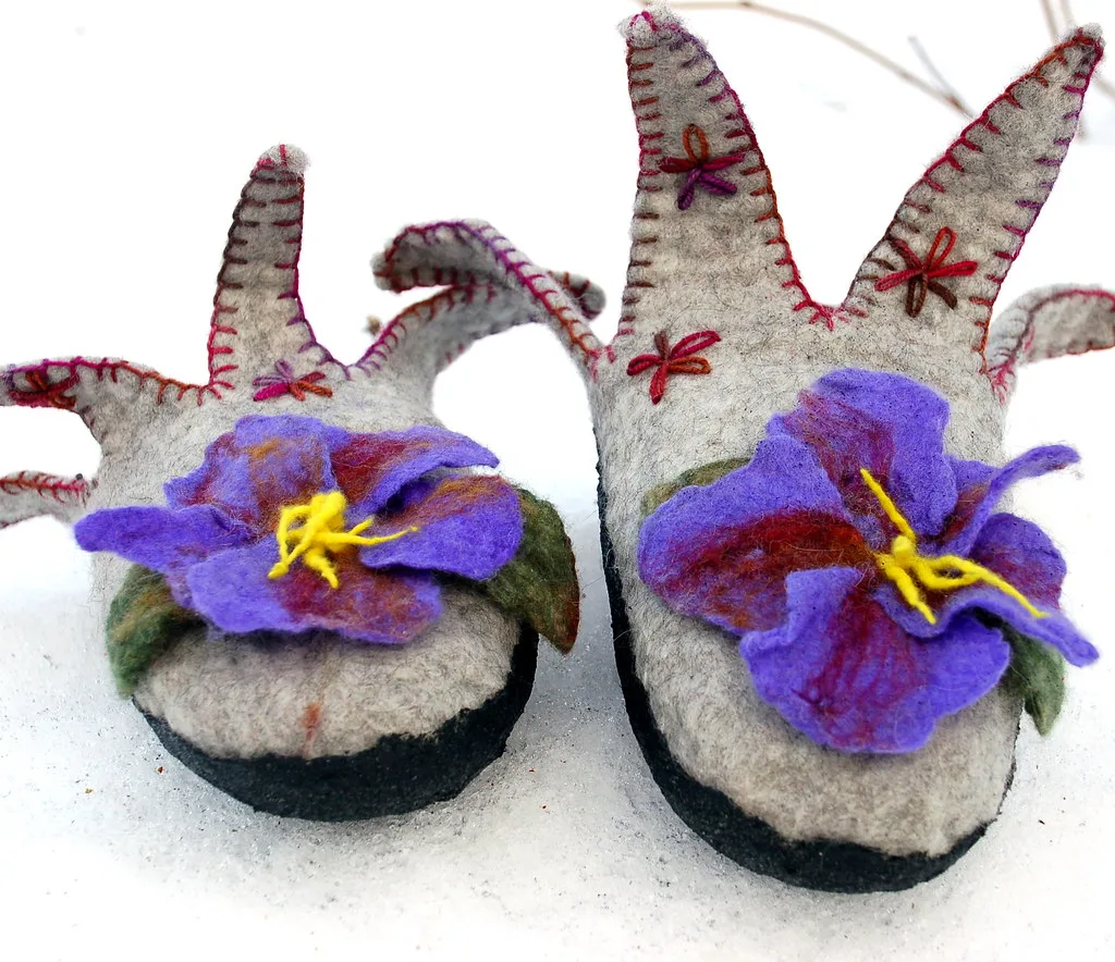 Wet felted slippers with dark rubber soles bonded to the underside