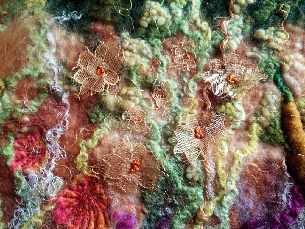A wet felted picture of a summer field, made from loose wool